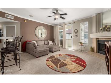 Comfortable living room with fireplace, neutral carpet, slider and stylish sectional sofa at 2992 N Miller Rd # 219B, Scottsdale, AZ 85251
