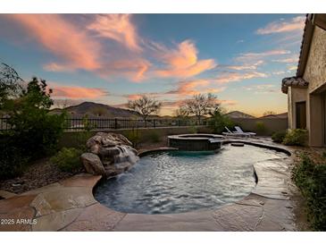 Resort style pool and spa with rock waterfall feature and mountain views at 3318 W Ravina Ln, Anthem, AZ 85086