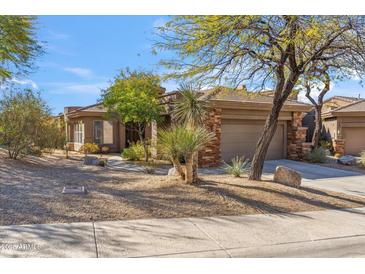 Charming single-story home with desert landscaping and stone accents on a sunny day at 7435 E Quien Sabe Way, Scottsdale, AZ 85266