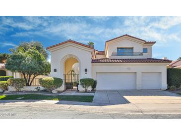 Elegant two-story home featuring arched entry, tile roof, and a two-car garage at 7667 E Krall St, Scottsdale, AZ 85250