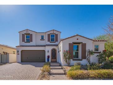 Charming two-story home featuring a well-maintained front yard, brick driveway and neutral colored stucco at 9729 E Theia Dr, Mesa, AZ 85212