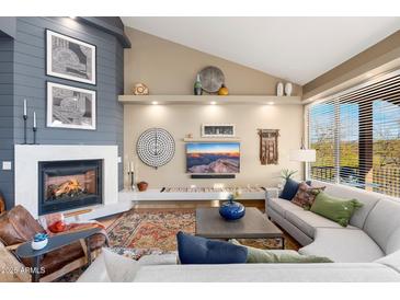Comfortable living room with a fireplace, stylish decor, and a large window with natural light at 16341 E Links Dr, Fountain Hills, AZ 85268