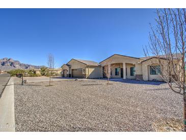 Desert home with a circular gravel driveway, three car garage and mountain views at 1727 E Hidalgo St, Apache Junction, AZ 85119