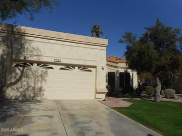 Beige single-level home with a two-car garage, desert landscaping, and a red tile roof at 19420 N Westbrook Pkwy # 510, Peoria, AZ 85382