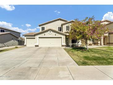 Charming two-story home with a well-manicured front yard, mature tree, and a spacious three-car garage at 4304 E Whitehall Dr, San Tan Valley, AZ 85140