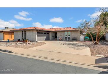 Charming single-story home featuring a tile roof, brick exterior, and a well-manicured desert landscape at 5141 E Elena Ave, Mesa, AZ 85206