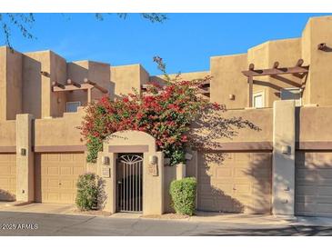 Charming condo exterior showcasing desert landscaping, private garages, and gated entry at 7021 E Earll Dr # 223, Scottsdale, AZ 85251