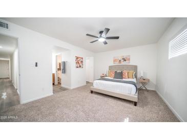 This bedroom offers a ceiling fan and an ensuite bathroom for convenience at 7928 N 46Th Ave, Glendale, AZ 85301