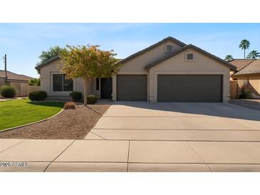 Charming single-story home with a well-manicured lawn, mature landscaping, and a two-car garage at 804 N Jamaica Way, Gilbert, AZ 85234