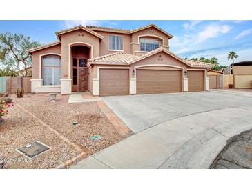 Charming home featuring a three-car garage, neutral paint, and low-maintenance desert landscaping at 15819 W Ripple Rd, Goodyear, AZ 85338