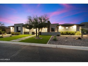 Stunning modern home featuring lush landscaping, desert rock accents and an eye-catching facade at 16908 S 31St Ln, Phoenix, AZ 85045