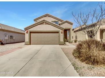 Tan two-story home featuring a large front-facing garage and desert landscaping at 1726 E Cortez Dr, Casa Grande, AZ 85122