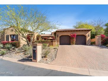 Charming single-story home featuring a terracotta roof, brick driveway and mature desert landscaping at 18683 N 101St Pl, Scottsdale, AZ 85255