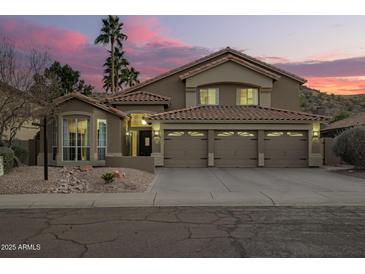 Charming two-story home with desert landscaping, a three-car garage, and a tile roof at 2633 E Amber Ridge Way, Phoenix, AZ 85048