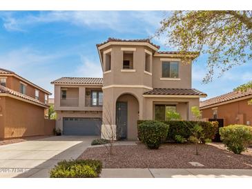 Two-story home featuring a turret entry, a balcony, desert landscaping, and a two-car garage at 3891 E Melrose St, Gilbert, AZ 85297