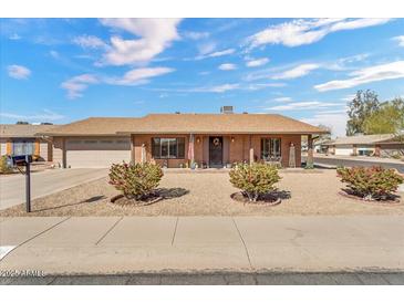 Charming single-story home with a brick facade, well-maintained gravel yard, and mature landscaping at 4826 E Navajo Cir, Phoenix, AZ 85044