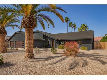 Charming one-story home features desert landscaping, a newer roof, and a wooden garage door at 5726 E Woodridge Dr, Scottsdale, AZ 85254