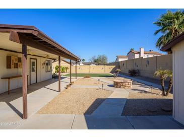 The backyard features a cozy fire pit and easy to maintain desert landscaping at 7335 W Mission Ln, Peoria, AZ 85345