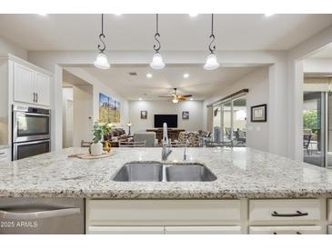 Open kitchen view, showcasing granite counters, stainless steel sink, and spacious open layout to living areas at 10049 E Topaz Ave, Mesa, AZ 85212