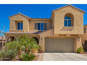 Inviting two-story home with a tan stucco exterior, arched windows, and a well-maintained front yard at 3103 S Dakota Pl, Chandler, AZ 85248