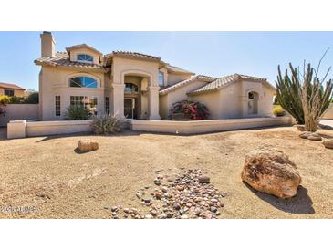 Stunning two-story home featuring desert landscaping, a tile roof, and an arched entry at 4803 W Buckskin Trl, Phoenix, AZ 85083