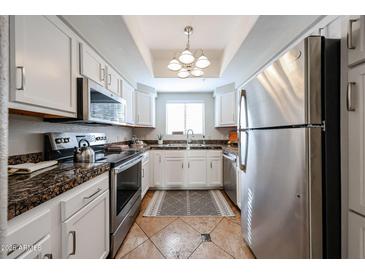 Well-lit kitchen with stainless steel appliances, granite countertops, and white cabinetry at 750 E Northern Ave # 1079, Phoenix, AZ 85020