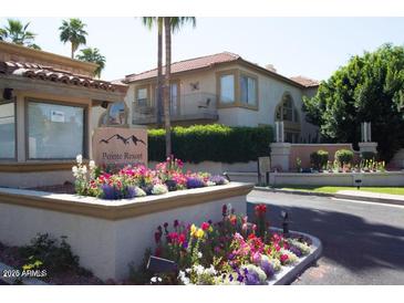 Charming condo building with a tile roof and colorful flower beds in a well-maintained community at 10224 N 12Th Pl # 1, Phoenix, AZ 85020