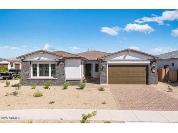 Beautiful single-story home featuring a brick driveway, well-kept landscape and attached two car garage at 14194 W Sand Hills Rd, Surprise, AZ 85387