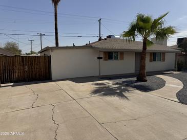 Charming single-story home featuring desert landscaping and a spacious concrete driveway at 3807 N 64Th Dr, Phoenix, AZ 85033