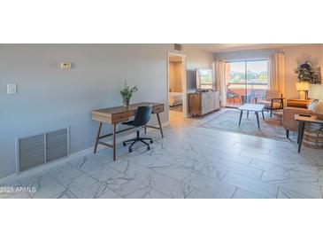 Bright living room featuring tile floors, a work space and a cozy seating area with balcony access at 4303 E Cactus Rd # 326, Phoenix, AZ 85032