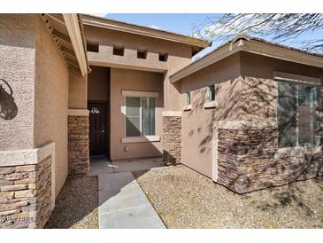Inviting single-story home with a stylish mix of stucco and stone exterior accents, plus a covered front entrance at 8962 W Grovers Ave, Peoria, AZ 85382