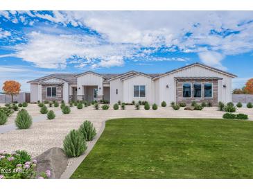 Stunning single-story home featuring a manicured lawn and attractive desert landscaping at 20274 W Highland Ave, Litchfield Park, AZ 85340