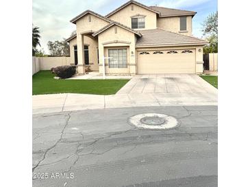 Charming two-story home with a well-manicured lawn and attached two-car garage and desert landscaping at 2602 E Glass Ln, Phoenix, AZ 85042