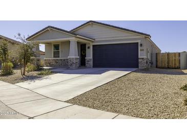 Charming single-story home with a well-maintained lawn and a two-car garage and stone veneer at 281 S San Gregorio Ln, Casa Grande, AZ 85194
