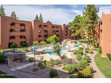 Stunning outdoor community pool area with water feature, mature trees, and seating at 4303 E Cactus Rd # 308B, Phoenix, AZ 85032