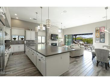 Bright, open-concept living room features modern decor, a large kitchen island, and an easy flow to the backyard oasis at 9671 E West View Dr, Scottsdale, AZ 85255