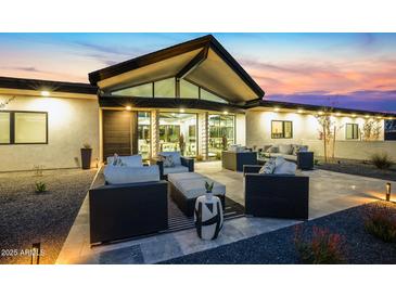 The modern home has a large patio furnished with sophisticated outdoor seating, perfect for entertaining and relaxation at 12201 N 65Th St, Scottsdale, AZ 85254