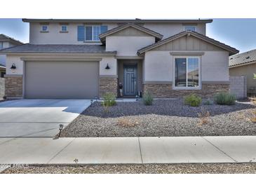 Charming two-story home featuring desert landscaping, a two-car garage and stone veneer accents at 16873 W Fetlock Trl, Surprise, AZ 85387