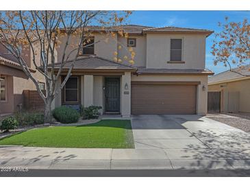 Charming two-story home with neutral exterior, well-manicured lawn and attached two car garage at 18039 W Sunnyslope Ln, Waddell, AZ 85355