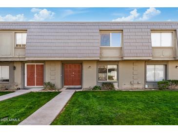 Inviting townhouse featuring charming architecture, a well-manicured lawn, and a welcoming facade at 2048 W Elm St, Phoenix, AZ 85015