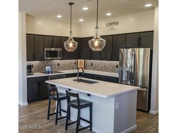 Modern kitchen with stainless steel appliances, stylish pendant lighting, and a large center island at 250 W Queen Creek Rd # 229, Chandler, AZ 85248