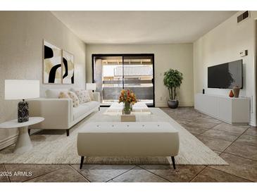 Bright living room with modern furnishings and sliding glass doors leading to the outside at 3825 E Camelback Rd # 292, Phoenix, AZ 85018