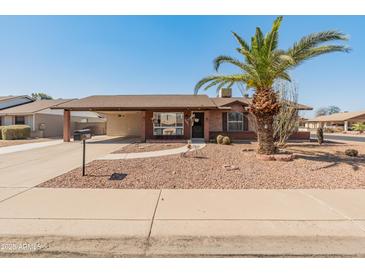 Charming single-story brick home with desert landscaping and covered carport at 8540 N 104Th Ave, Peoria, AZ 85345