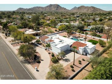 Stunning aerial view of a modern home with a pool, pristine landscaping, and mountain views at 9900 N 52Nd St, Paradise Valley, AZ 85253