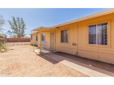 Tan single-story home with minimal front landscaping and covered walkway to front door at 207 E Cedar Ave, Casa Grande, AZ 85122