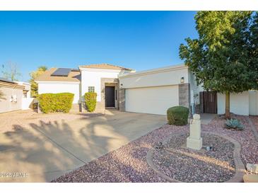 Charming single-story home with a two-car garage, desert landscaping, and a well-manicured lawn at 3019 E Redfield Rd, Phoenix, AZ 85032