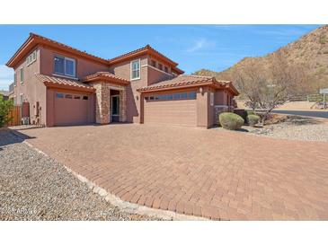 Attractive two story home with brick driveway and three car garage, under a blue sky at 34714 N 21St Ln, Phoenix, AZ 85086