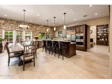 Spacious open kitchen with a large center island, stone wall and modern stainless steel appliances at 1516 W Port Au Prince Ln, Phoenix, AZ 85023