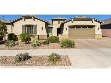 Charming single-story home with a desert landscape, a paver driveway, and a two-car garage at 20520 E Mockingbird Dr, Queen Creek, AZ 85142