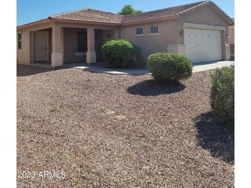 Charming single-story home featuring a well-maintained landscape and a covered porch at 24930 W Dove Mesa Dr, Buckeye, AZ 85326